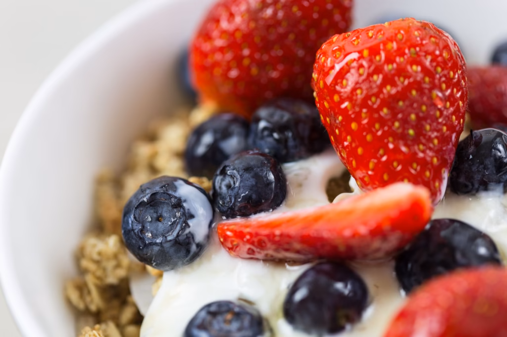 A bowl of oatmeal topped with berries and a spoonful of yogurt, illustrating a fiber‑rich, probiotic‑friendly breakfast