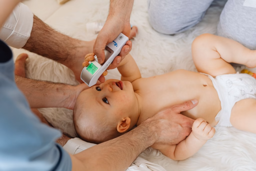 A child having their temperature taken, illustrating how parents assess a fever