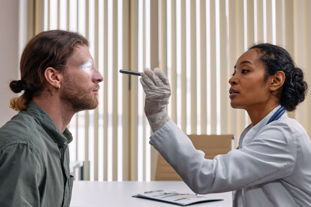 A clinician checks a patient’s eye for signs of adenoviral conjunctivitis