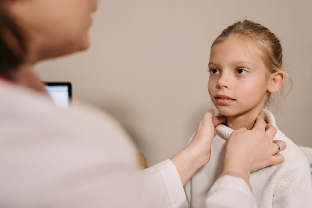 A clinician gently assesses neck movement and tenderness during a routine exam