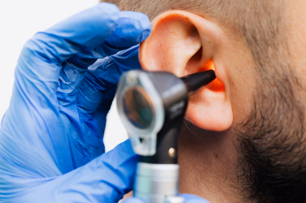 A clinician using an otoscope to view the eardrum, illustrating how infections are identified