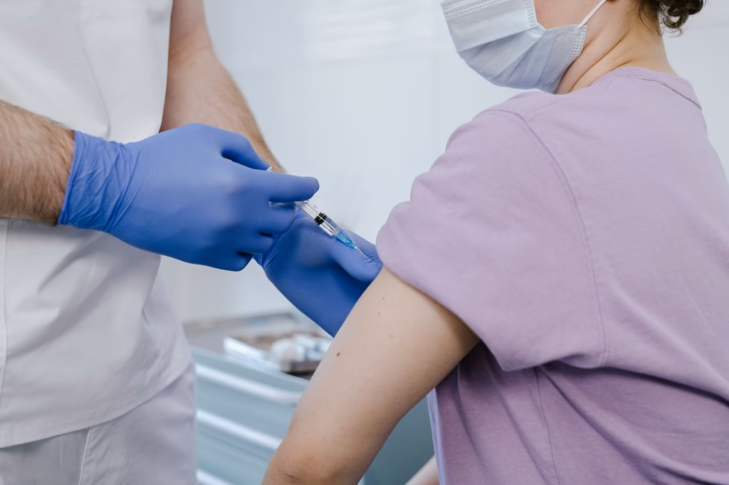 A healthcare worker administering a vaccine, representing preventive care against viral diseases