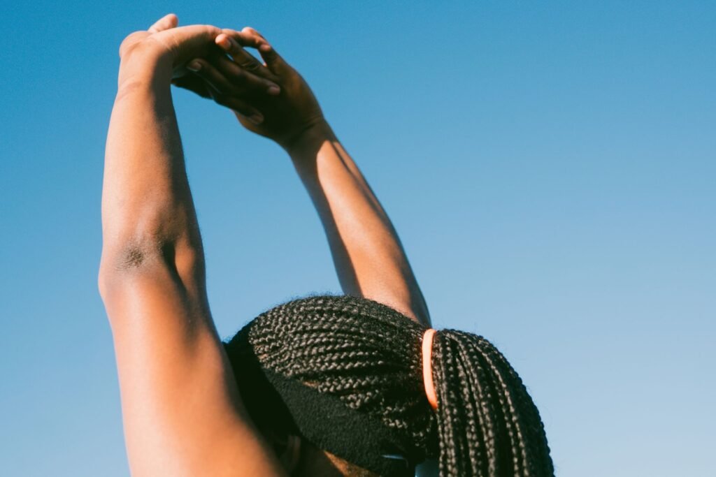 A person stretching arms above the head, showing gentle movement to ease muscle stiffness