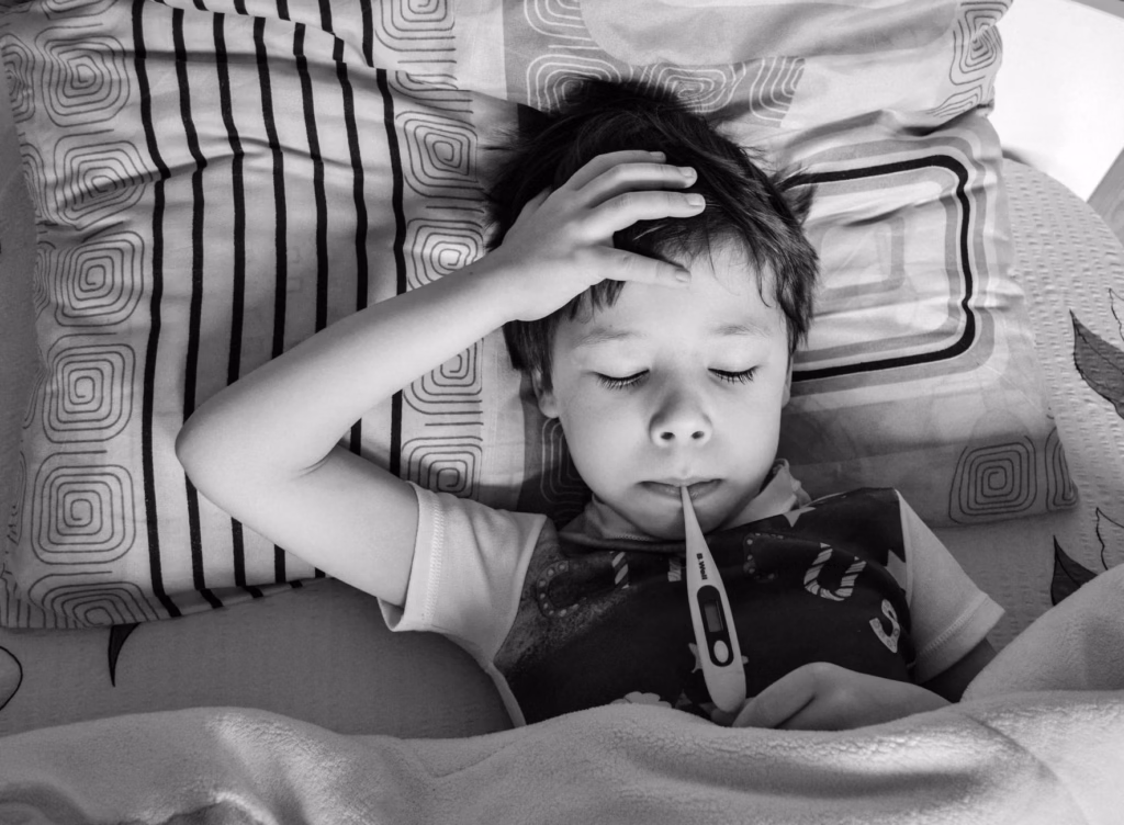 A sleepy child tucked in bed, illustrating a night‑time fever episode