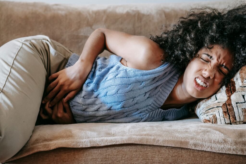 A woman gently holding her abdomen, illustrating relief from bloating