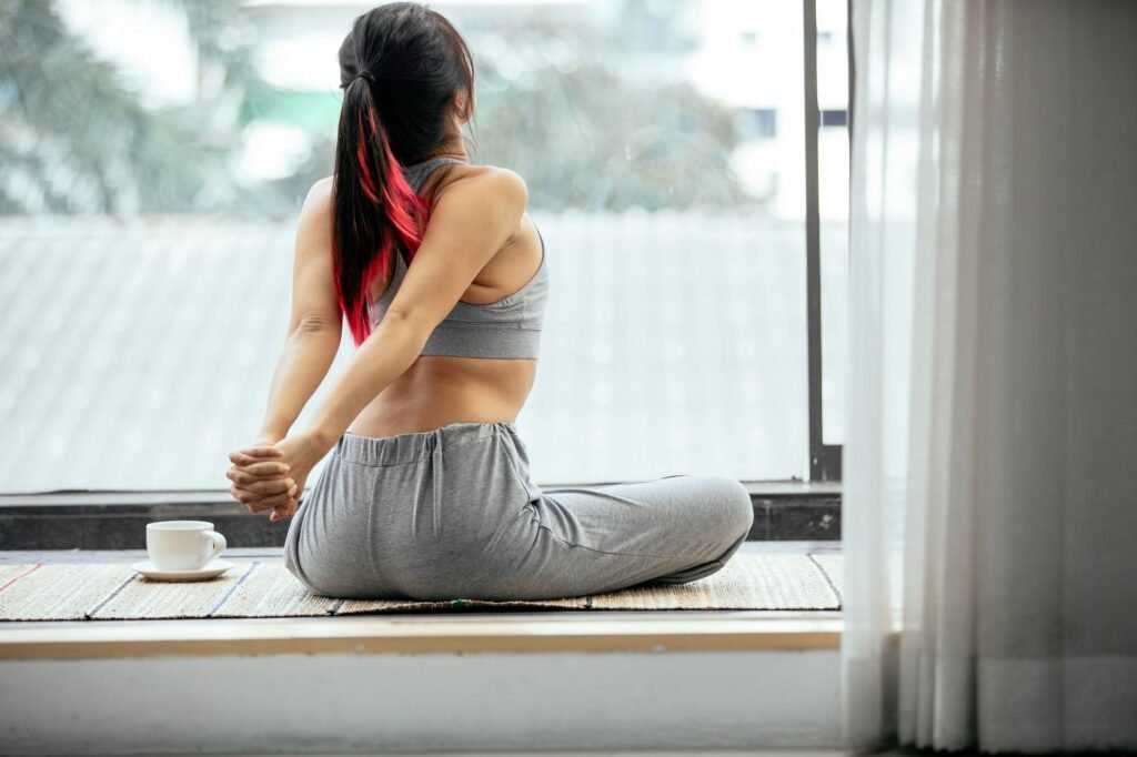A woman gently stretches her back to illustrate safe mobility exercises