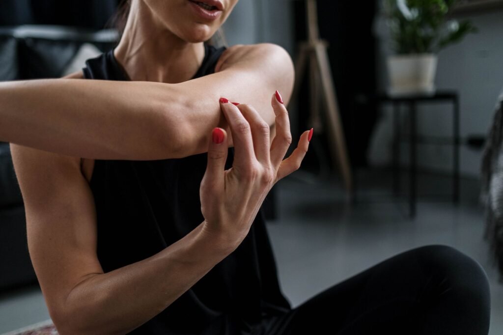 A woman gently stretching her arm, demonstrating a safe home exercise for stiff joints
