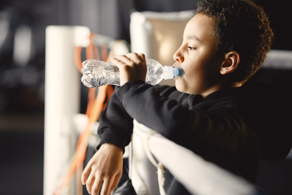 Child sipping water to stay hydrated during a fever