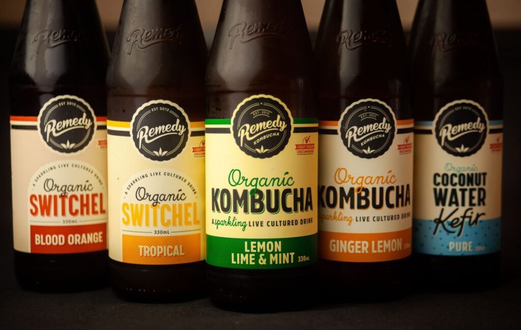 Close-up of five bottles featuring organic kombucha, switchel, and kefir with various flavors