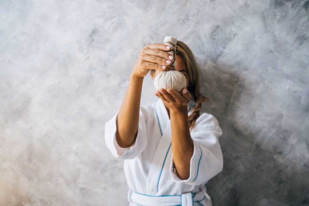 Hands applying a warm compress to the cheek area to soothe sinus‑related jaw pain